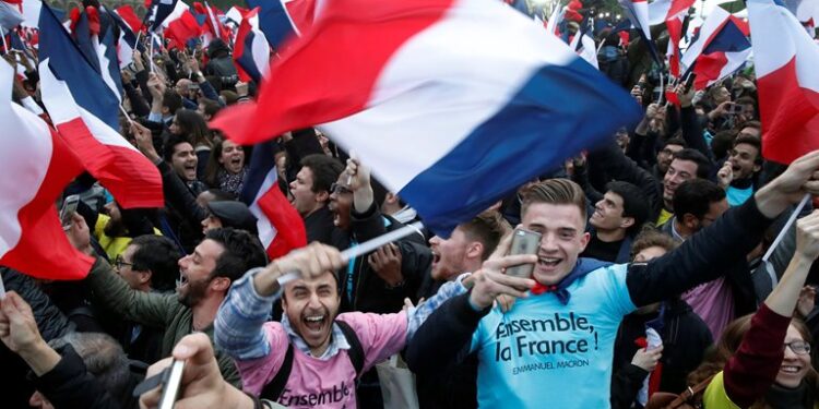 Supporters of French President Elect Emmanuel Macron celebrate near the Louvre museum after early results were announced in the second round vote in the 2017 presidential elections in Paris, France, May 7, 2017.   REUTERS/Christian Hartmann