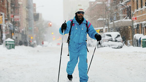 Мужчина катается на лыжах во время снегопада в Нью-Йорке