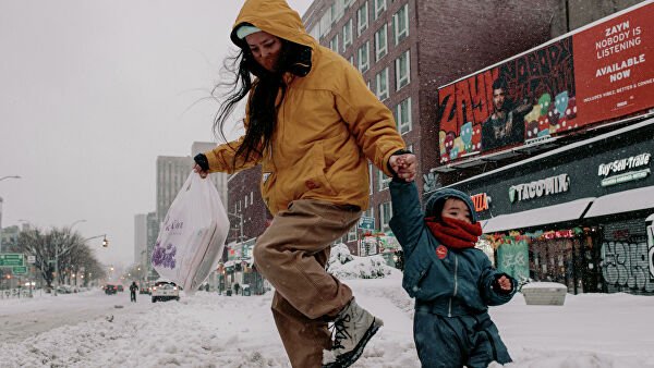 Женщина с ребенком на заснеженной улице Манхэттена