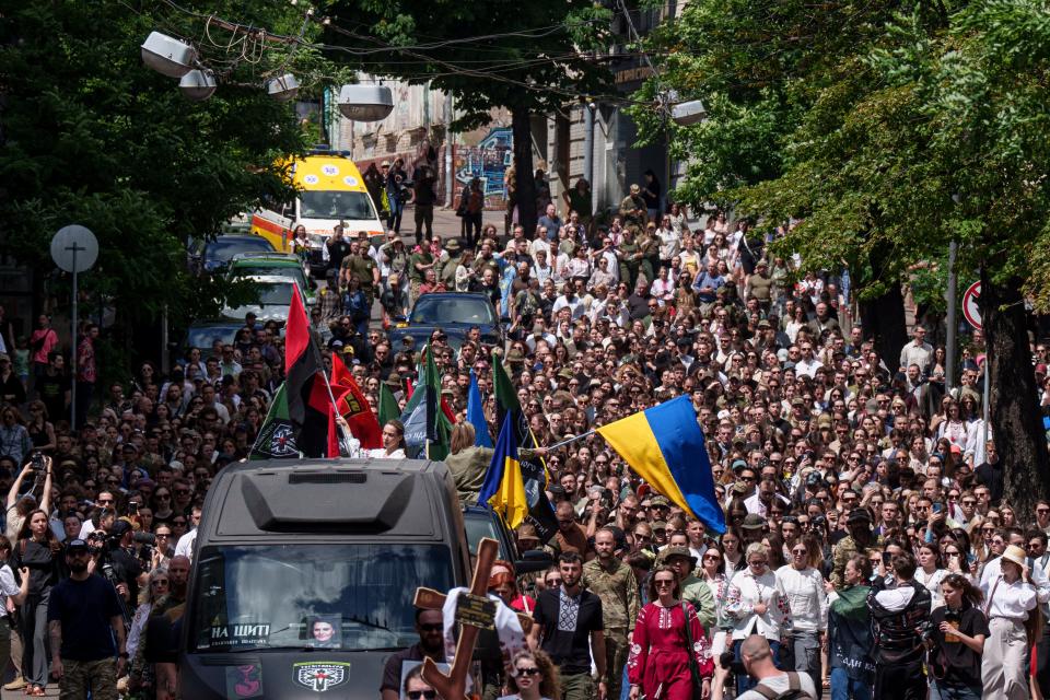 People walk along Mykhailivska Street during a memorial service for Ukrainian journalist and volunteer combat medic Iryna Tsybukh at St. Michael's Golden-Domed Monastery in Kyiv, (AP)